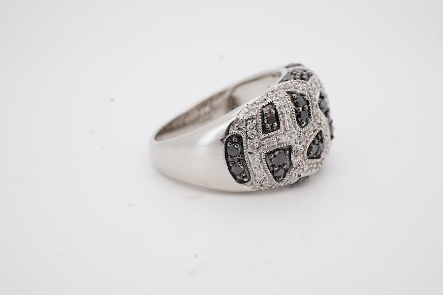 A recent 9ct white gold and two colour diamond cluster set dress ring, of abstract design, size N/O, gross weight 7.6 grams.